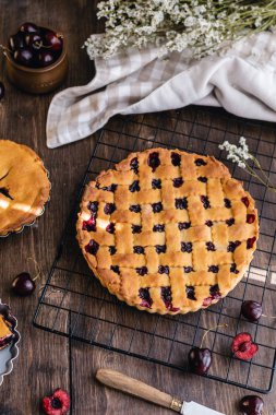 Kırsal ahşap arka planda malzemeleri olan taze vişneli turta.