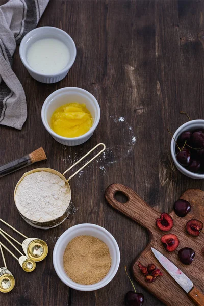 Хлібобулочні вироби, вишневий пиріг з інгредієнтами на сільському дерев'яному спині — стокове фото