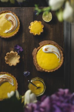 Koyu kırsal masada limon kremalı turta, limon suyu kavanozu, üst manzara, boşluk kopyala