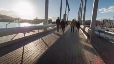 İspanya 'nın Barselona şehrinde güneşli bir günde köprüde yürüyüş videosu yayınlandı.