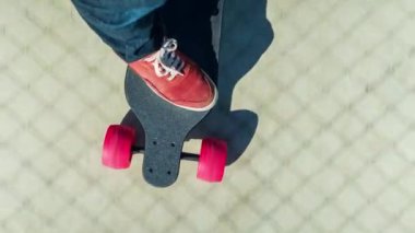 Zemin boyunca hareketli elektrik kaykay üzerinde kırmızı spor ayakkabı erkek ayak 