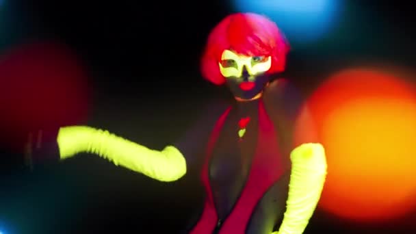 sexy junge Frau tanzt im UV-Kostüm