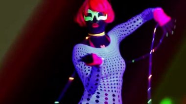 Seksi bayan disko dansçısı UV kostümüyle poz veriyor.