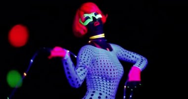 Seksi bayan disko dansçısı UV kostümüyle poz veriyor.