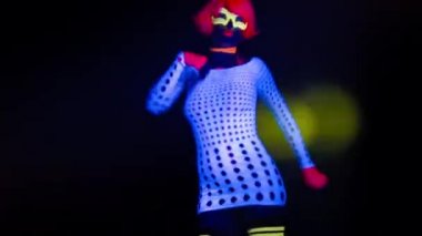 Seksi bayan disko dansçısı UV kostümüyle poz veriyor.