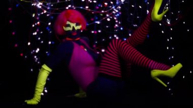 Seksi bayan disko dansçısı UV kostümüyle poz veriyor.