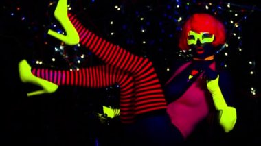Seksi bayan disko dansçısı UV kostümüyle poz veriyor.