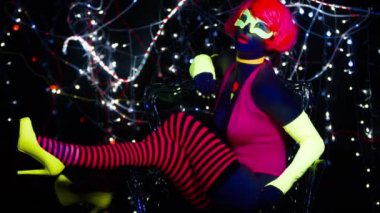 Seksi bayan disko dansçısı UV kostümüyle poz veriyor.
