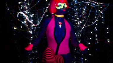 Seksi bayan disko dansçısı UV kostümüyle poz veriyor.