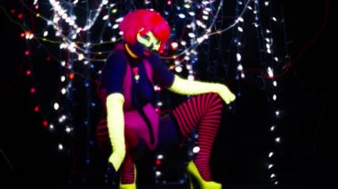 Seksi bayan disko dansçısı UV kostümüyle poz veriyor.