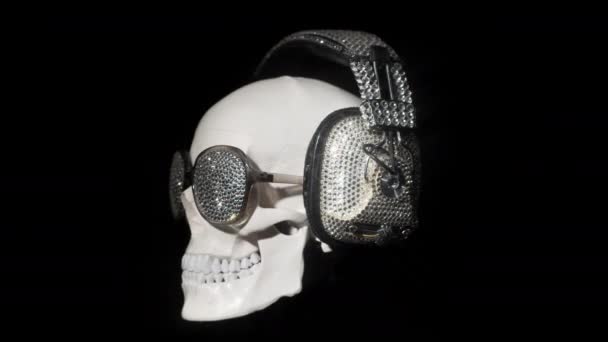 Κρανίο Περιστρεφόμενη Ενάντια Μαύρο Αφρώδη Ακουστικά Και Γυαλιά Ηλίου — Αρχείο Βίντεο