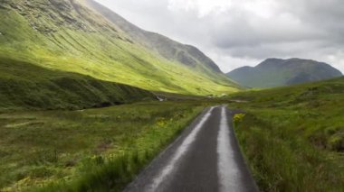 İskoç dağlık güzel boş yollar aracılığıyla sürüş bir aracın ön bağlı bir kamera çekim Pov