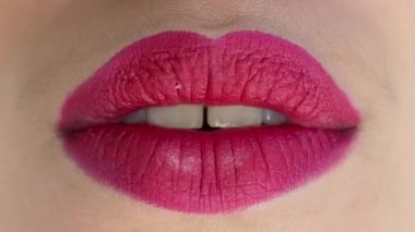 close-up footage of sexy female lips with pink lipstick, moving and kissing