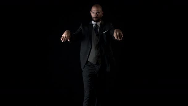黒の背景に現代的なスタイルで踊るスマート スーツの巧みな男性ダンサー — ストック動画