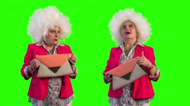 El çantası tutarak ve yeşil arka plan üzerinde etrafa yaşlı kadın