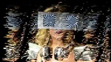 gözleri olarak iki video ekranlar ile etrafa bir kadın başkanı. ekranlar üzerinde bir hipnotik video döngü vardır