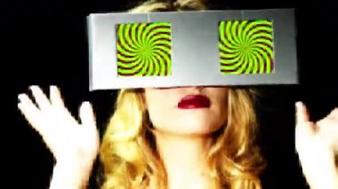 gözleri olarak iki video ekranlar ile etrafa bir kadın başkanı. ekranlar üzerinde bir hipnotik video döngü vardır