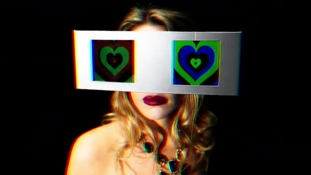 目として つのビデオ スクリーンで見回す女性の頭部 画面にハートの催眠ビデオを持っています — ストック動画
