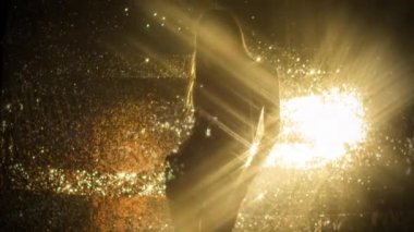 Güzel kadın altın parlak arka plan üzerinde dans 