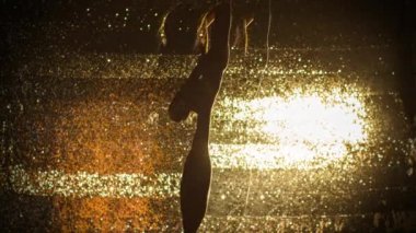 Güzel kadın altın parlak arka plan üzerinde dans 