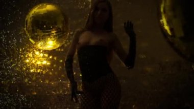 Güzel kadın altın disko topları yanında dans