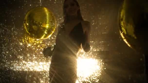 Schöne Frau Tanzt Neben Goldenen Discokugeln — Stockvideo