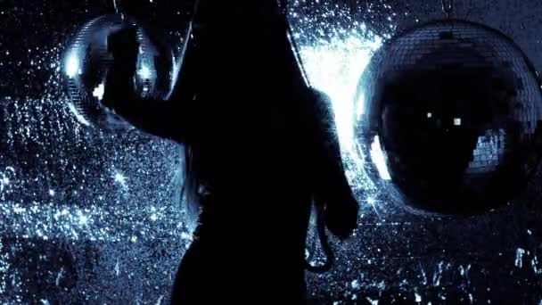 Femme attrayante dans les écouteurs dansant sur fond brillant 