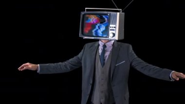 Bay Televizyon Şefi. Takım elbiseli havalı bir adam kafasında televizyonla dans ediyor. Televizyon parazitli ve gürültülü.