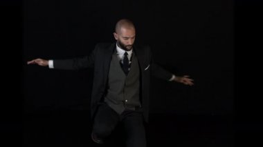 çağdaş bir tarzda siyah arka plan üzerine dans akıllı takım elbiseli usta erkek dansçı