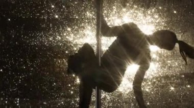 Onun becerilerini parlak arka plan üzerinde gösterilen kadın direk dansör