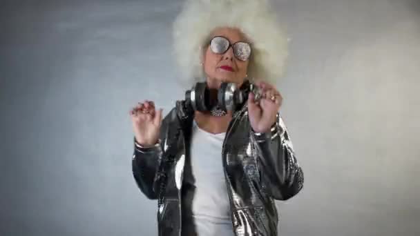 惊人的祖母在耳机和眼镜跳舞 — 图库视频影像