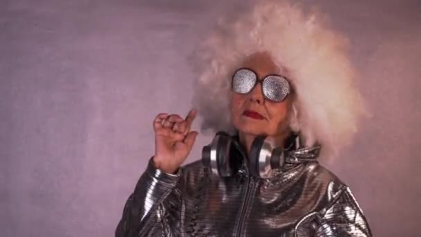 惊人的祖母在眼镜和耳机跳舞 — 图库视频影像