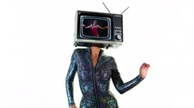 Seksi genç kadın dans ediyor ve televizyonla poz veriyor.