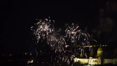 Şehir üzerinde patlayan farklı renkli havai fişek