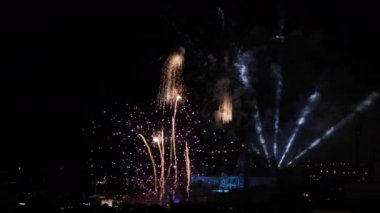 Şehir üzerinde patlayan renkli havai fişek