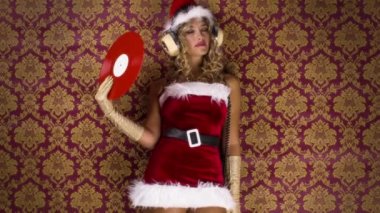 güzel sarışın kadın ile vinil kayda Noel zaman disko çekimi için klasik duvar kağıdı karşı sallayarak sevimli Noel Baba kostüm
