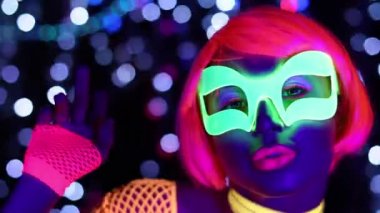 Seksi bayan disko dansçısı UV kostümüyle poz veriyor.