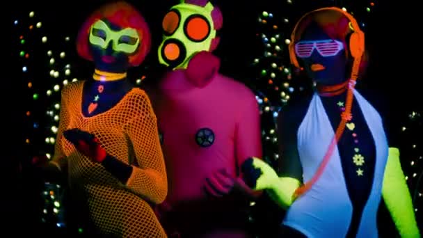 セクシーな女性と ブラック ライト下で蛍光服にガスマスクの男 — ストック動画