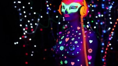 Floresan gözlük ve kulaklık Uv ultraviyole ışık altında genç çekici kadın