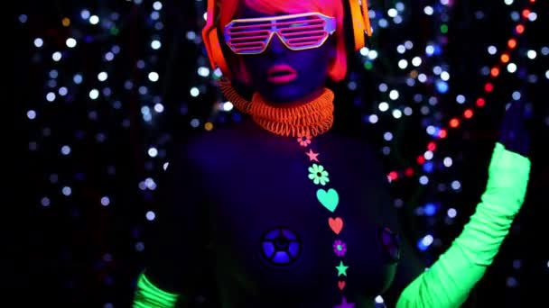 在紫外线黑光下荧光眼镜和耳机的梦幻性感女人 — 图库视频影像