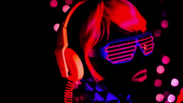 背景のライトと ブラック ライト下で蛍光服のセクシーな女性 — ストック動画