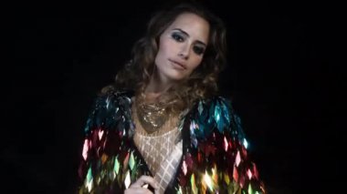 Poz ve şaşırtıcı bir metal tüy giymiş dans seksi kadın üst parıldıyor