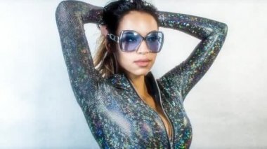 Güzel kadın gümüş kostüm ve güneş gözlüğü poz