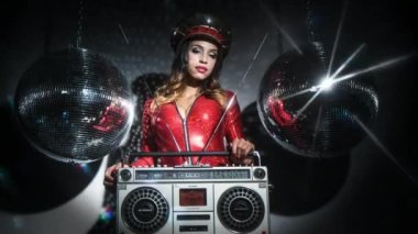 şaşırtıcı kırmızı catsuit çivili askeri şapka ve vintage Getto blaster ile poz seksi güzel kadın
