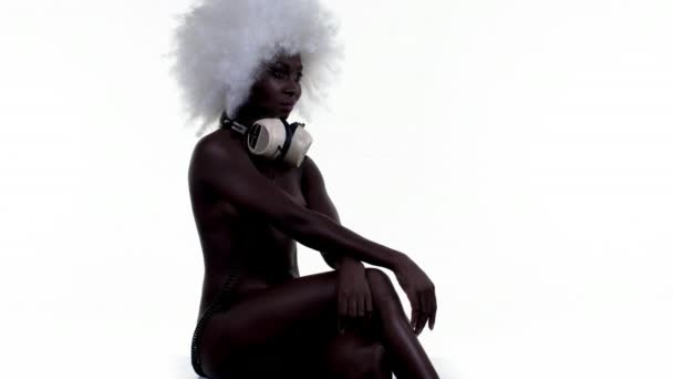 ヘッドフォン ホワイト バック グラウンドでポーズ美しい裸のアフリカの女性 — ストック動画