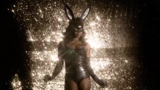 妇女跳舞与大兔子耳朵面具和黑乳胶身体在闪闪发光的背景 — 图库视频影像