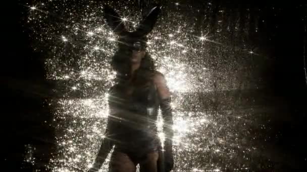 妇女跳舞与大兔子耳朵面具和黑乳胶身体在闪闪发光的背景 — 图库视频影像