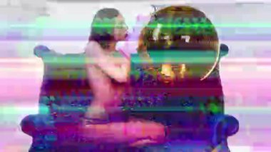 Disko topuyla kanepede oturan üstsüz seksi genç kadın. 