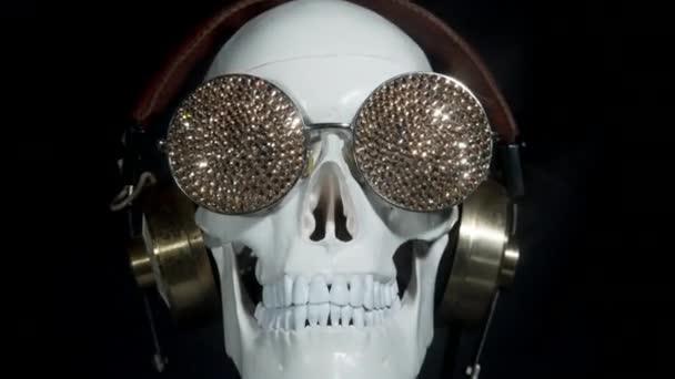 Cráneo Con Gafas Sol Brillantes Auriculares Sobre Fondo Negro — Vídeo de stock