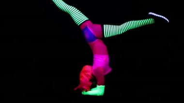 Kadın floresan giyim Uv ultraviyole ışık altında jimnastik egzersizleri yapıyor